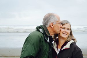 An elder couple kissing at the sea 