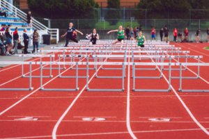 people racing over athletics hurdles