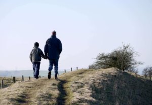 two people walking across hills
