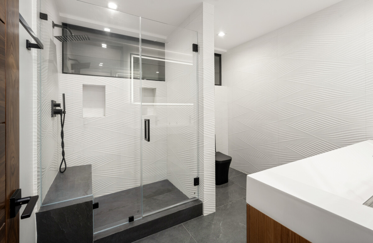 A spacious white bathroom with combined shower and sink and recessed spotlights