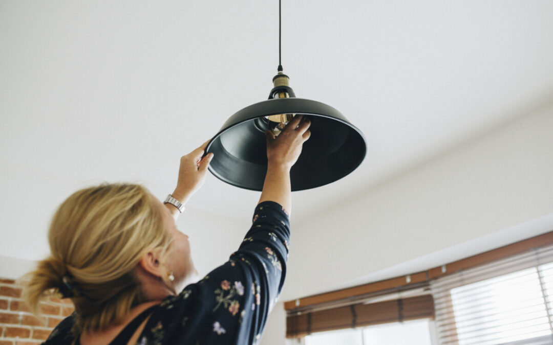 Woman changing a light bulb in her home