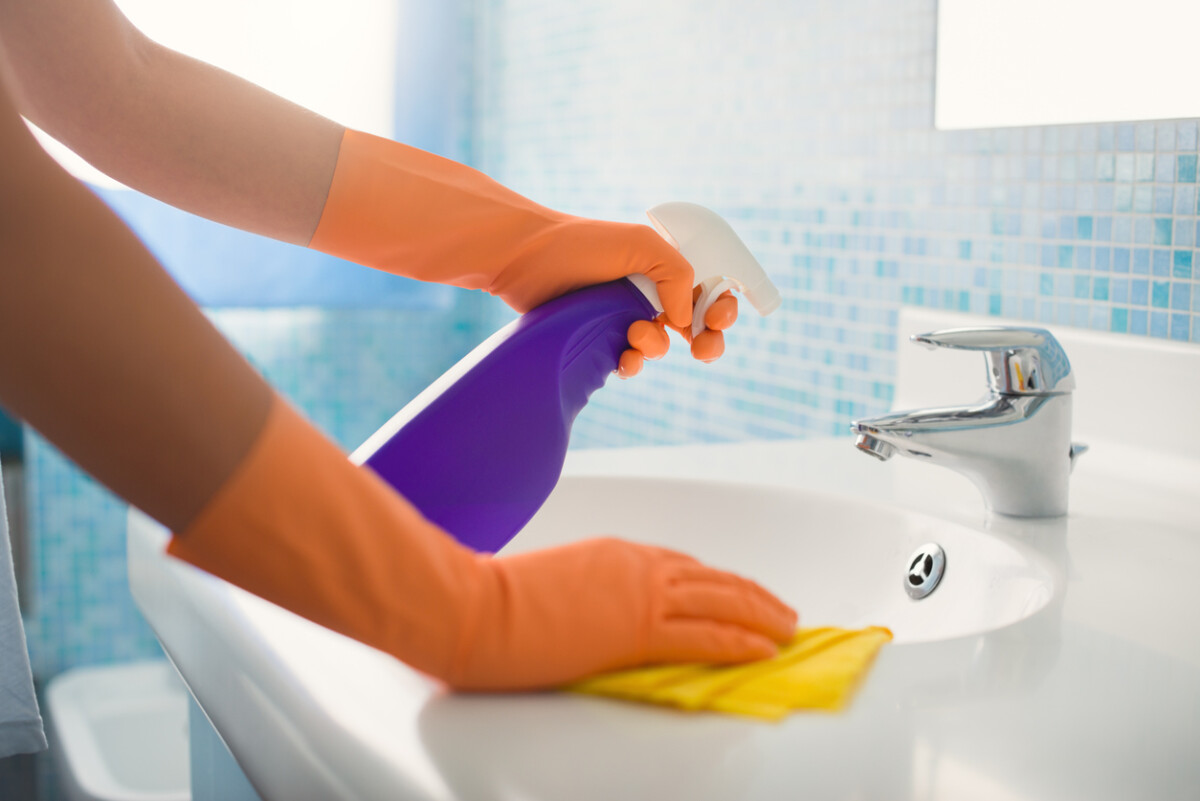 Woman cleaning a bathroom at home, focused on maintaining hygiene and a sparkling, fresh space.