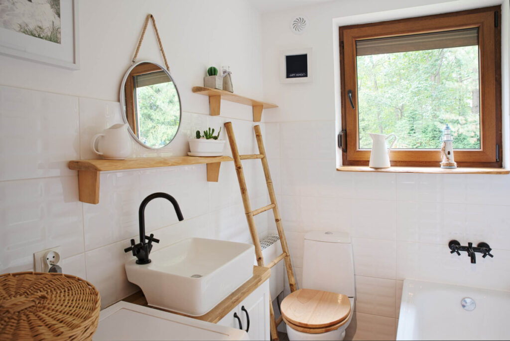 Small interior of bathroom with bathroom sink, toilet and window in a cottage.