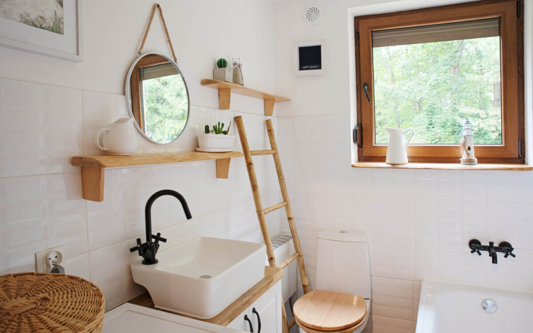 Small interior of bathroom with bathroom sink, toilet and window in a cottage.