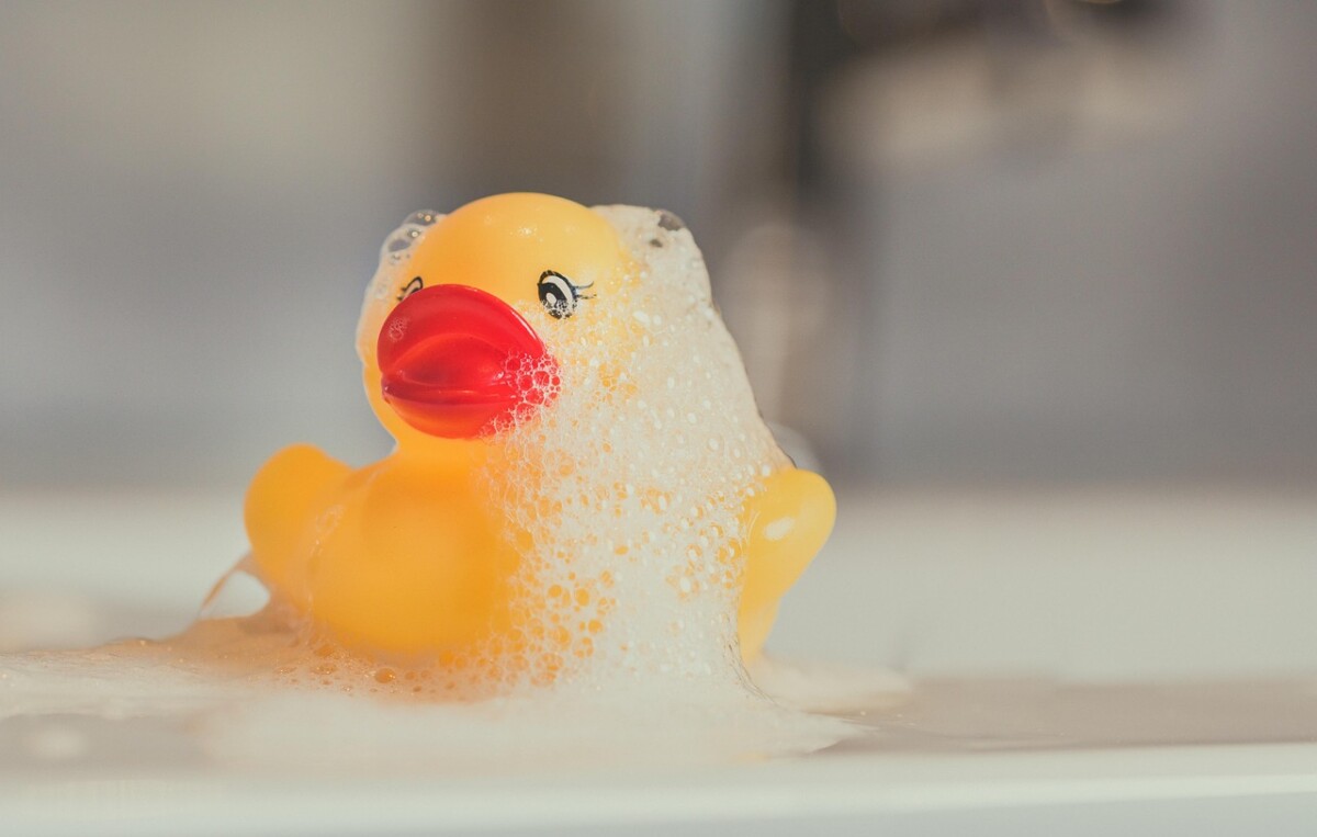 An image of a rubber duck with bubble bath on top